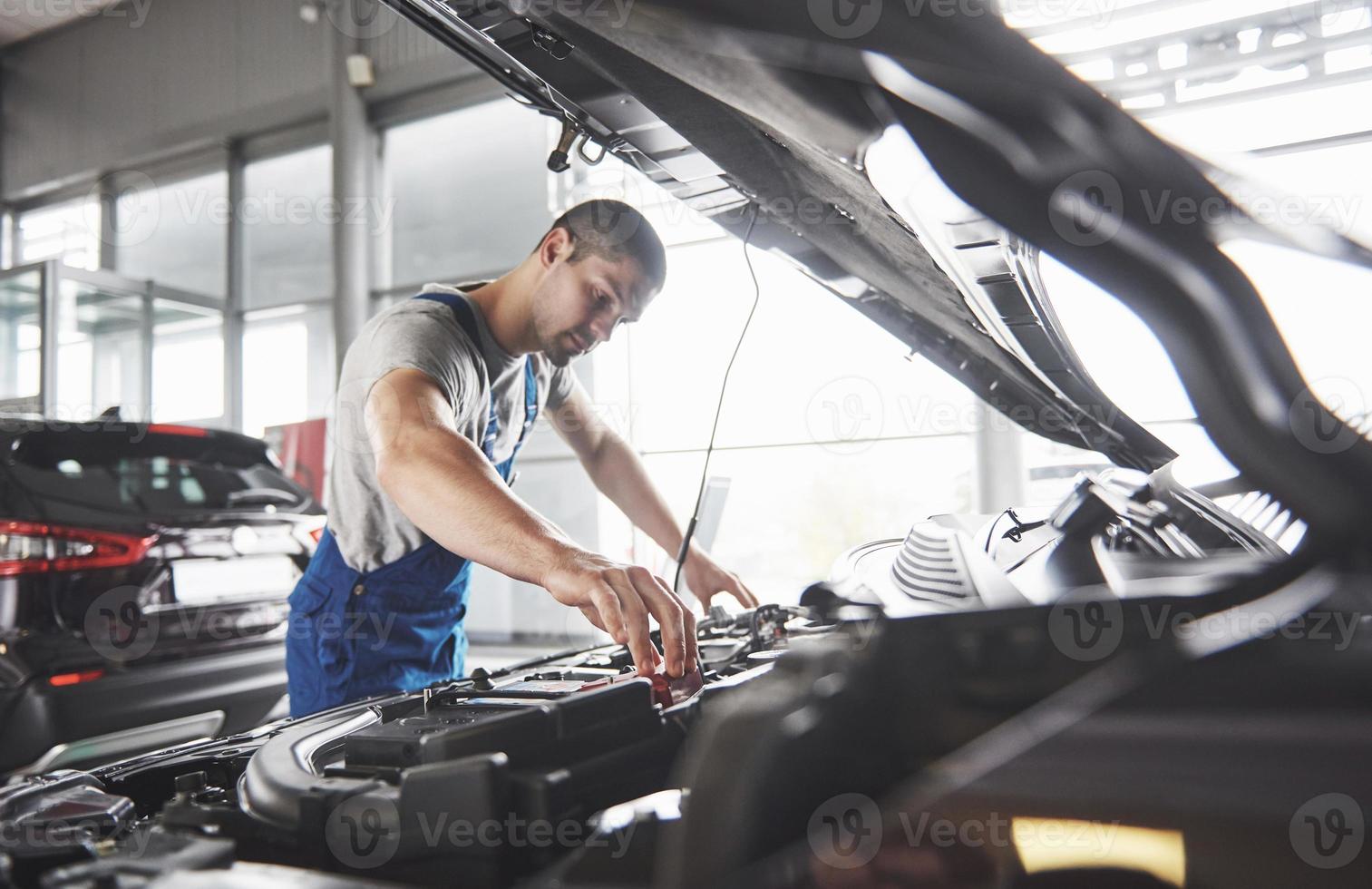 photo montrant un employé de service de voiture musclé réparant un véhicule