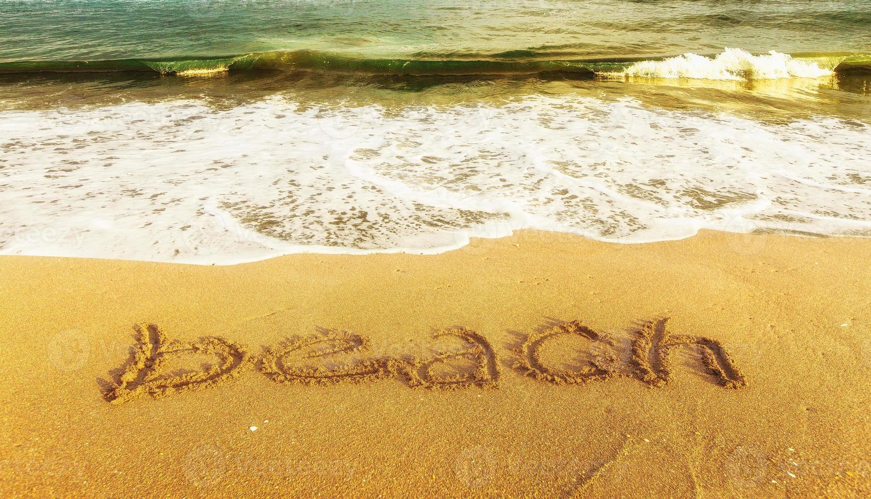 océan azur avec plage d'inscription sur le sable jaune photo