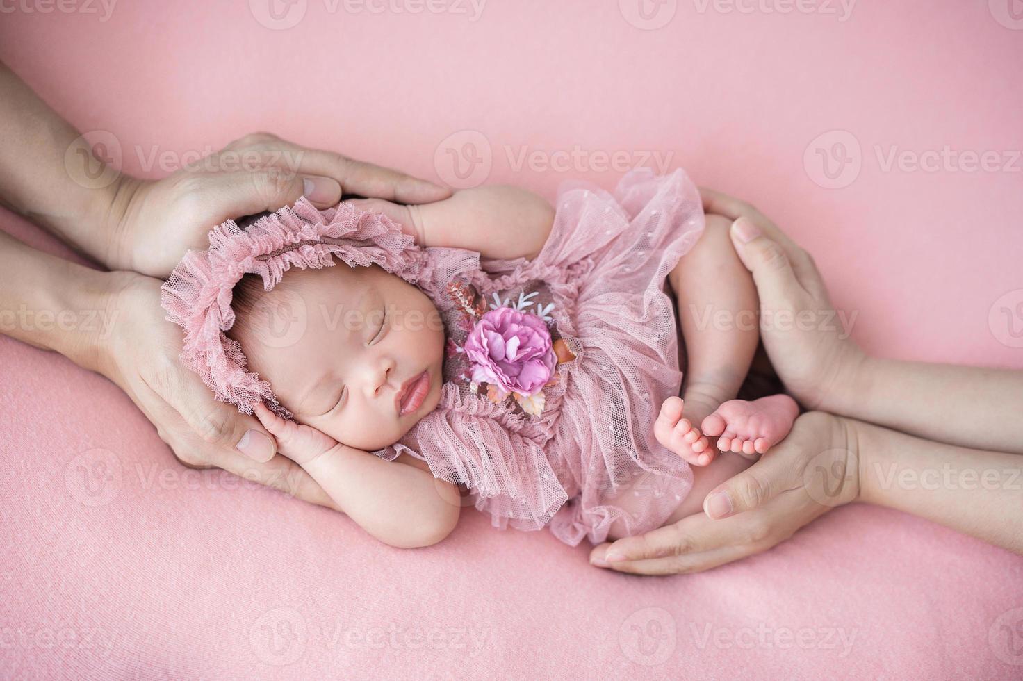 père et mère main tenant bébé nouveau-né endormi photo