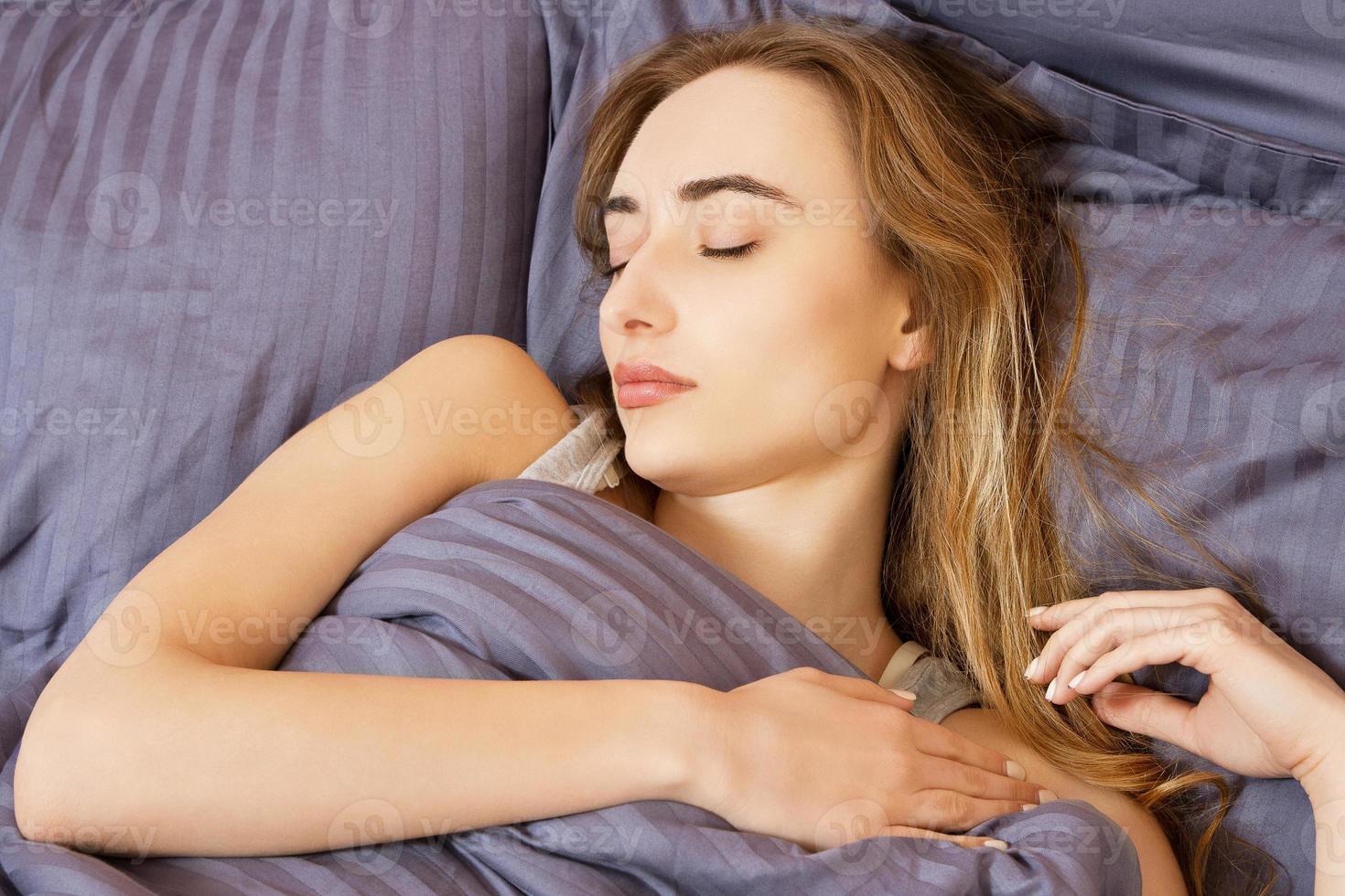 belle jeune femme asiatique se prélassant dans son lit le matin. beauté photo