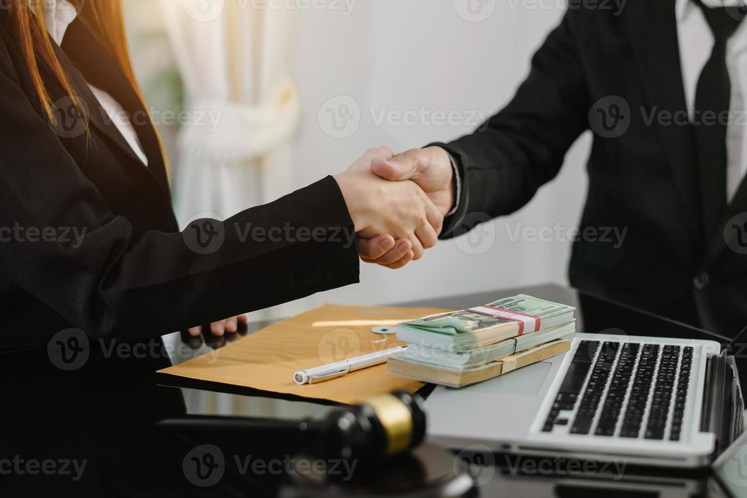 juge et client se serrant la main et avocats discutant des documents contractuels après avoir été conseillés en arrière-plan dans la salle d'audience, concept de service d'avocat photo