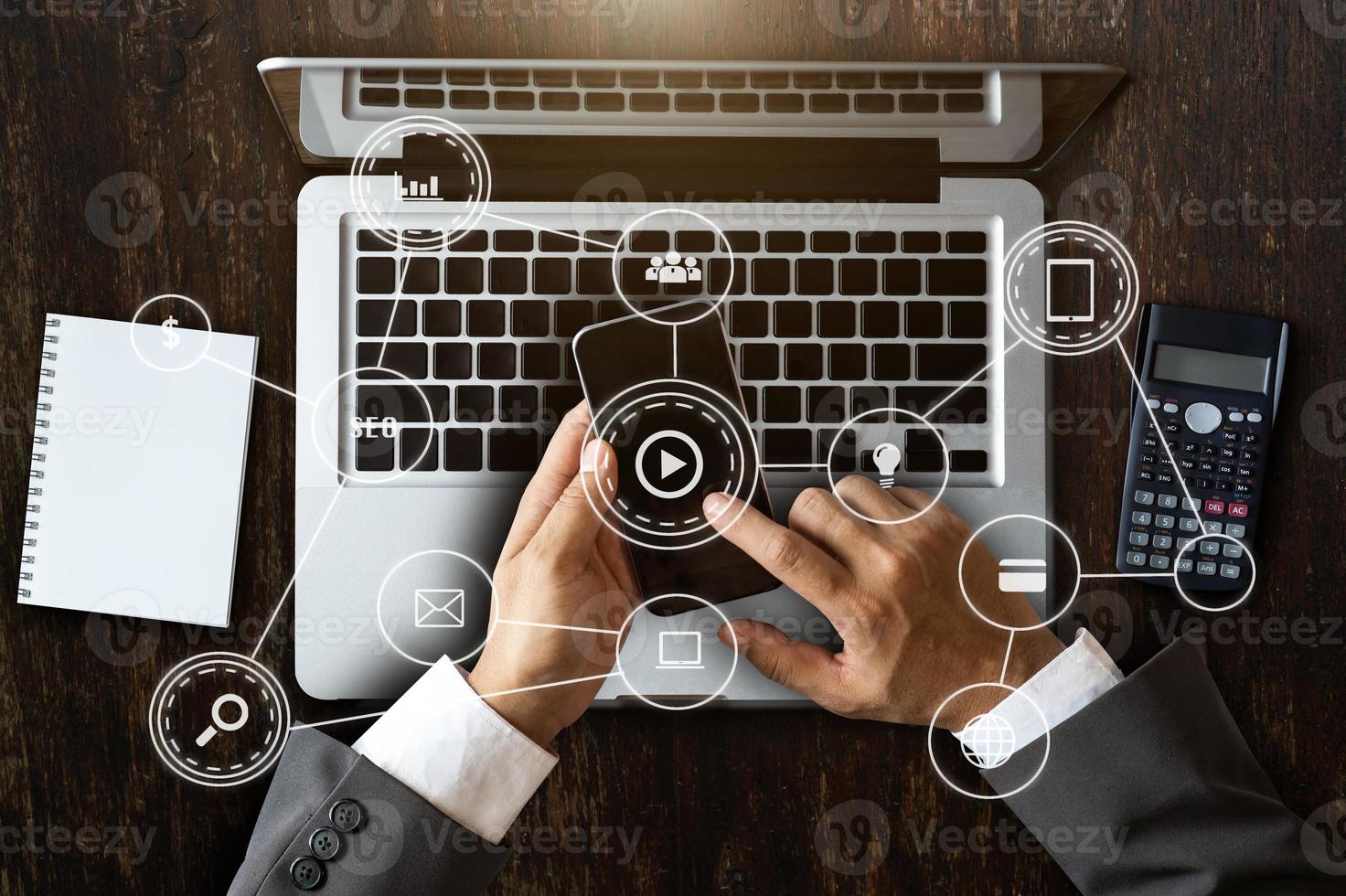 vue de dessus main d'affaires travaillant avec un ordinateur portable, une tablette et un téléphone intelligent au bureau avec des supports de marketing numérique photo