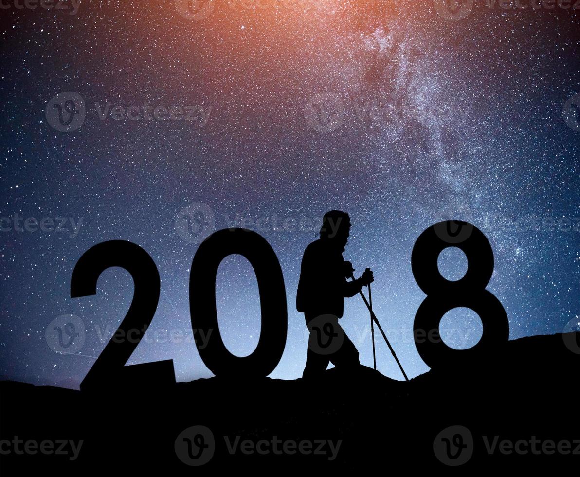 silhouette jeune homme randonneur pour le nouvel an 2018 fond de la voie lactée sur un ton de ciel sombre étoile brillante photo