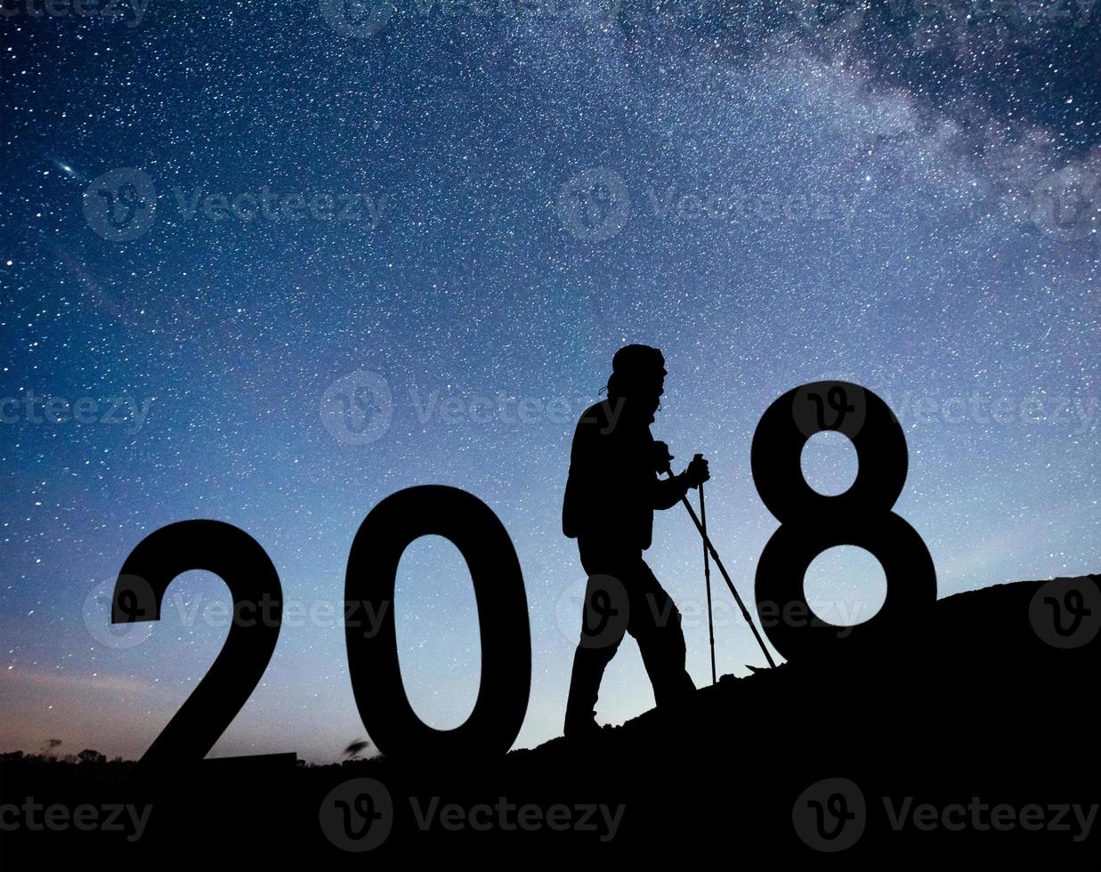 silhouette jeune homme randonneur pour le nouvel an 2018 fond de la voie lactée sur un ton de ciel sombre étoile brillante photo