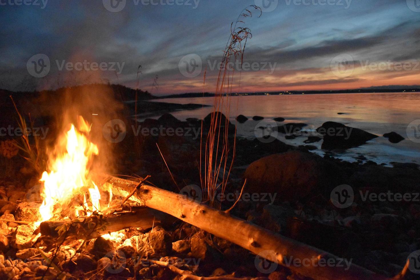 Firecamp sur le rivage au coucher du soleil dans l'archipel suédois photo