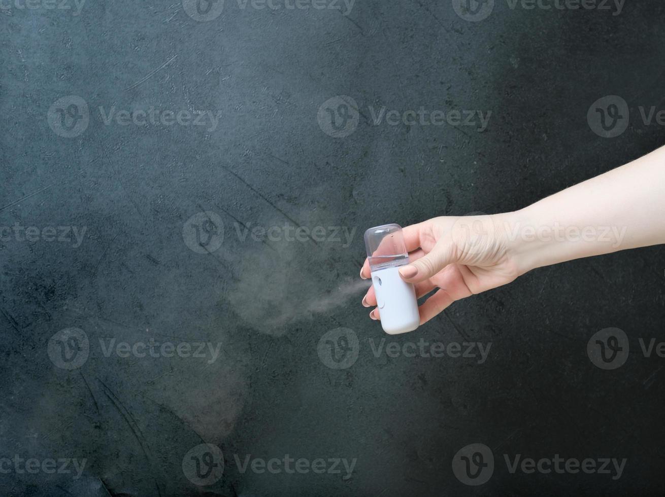main tenant un pulvérisateur de brouillard usb de voyage pour humidifier l'air et hydrater la peau. mini humidificateur pour l'hydratation du visage et les soins de la peau photo