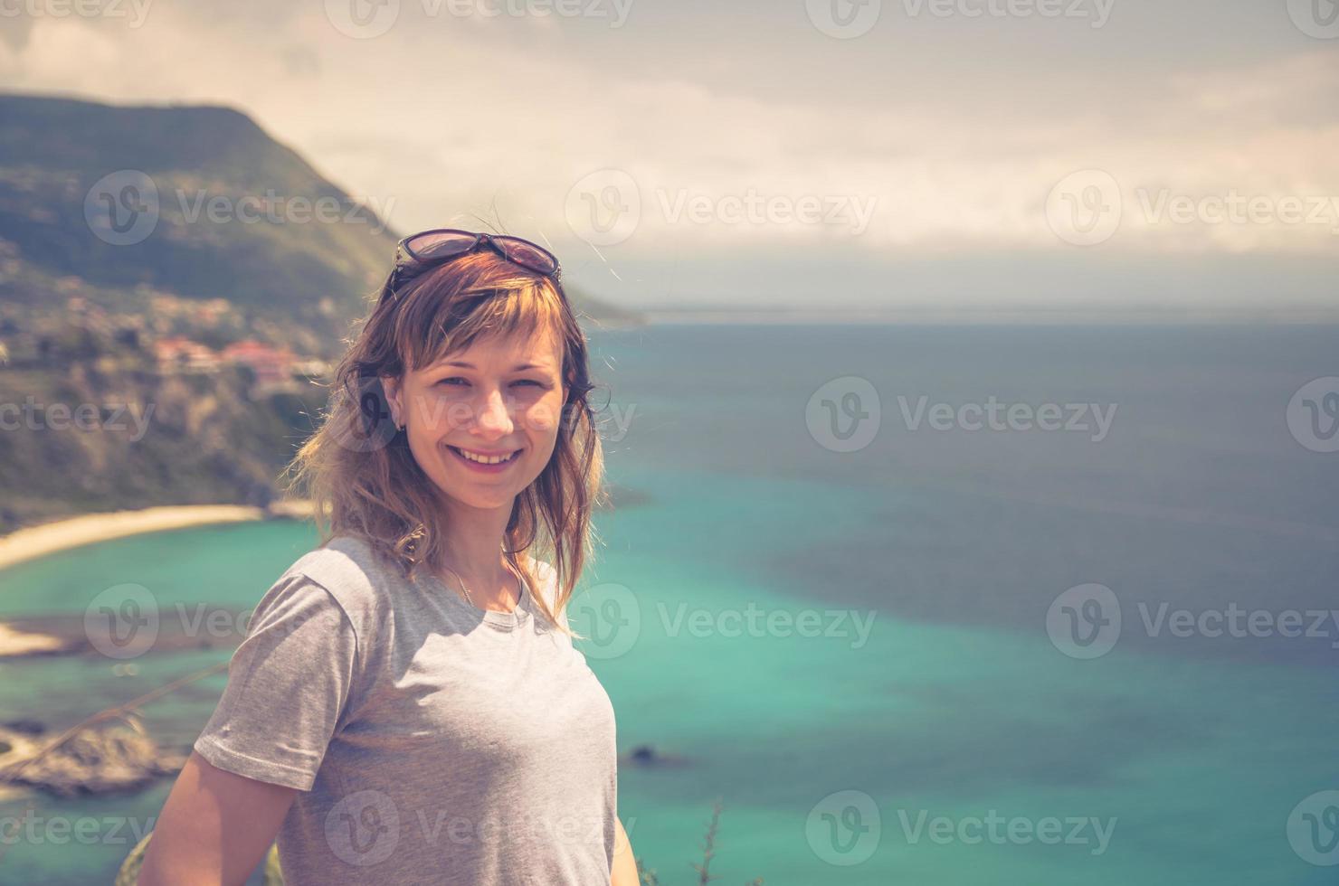 portrait en gros plan d'une jeune voyageuse caucasienne avec un t-shirt gris et des lunettes de soleil regardant la caméra photo