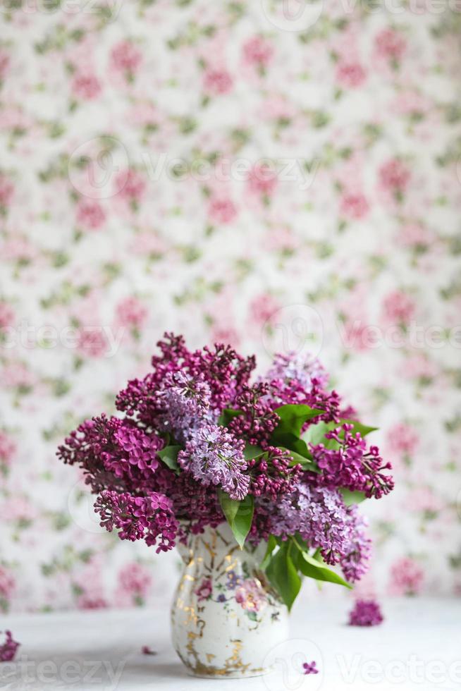 bouquet de lilas violet dans un vase. nature morte aux branches fleuries de lilas dans des vases. maquette de carte de voeux. espace pour le texte. photo