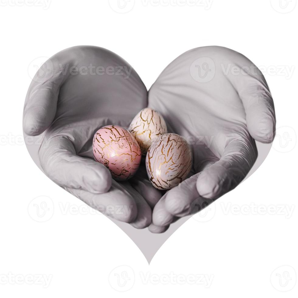 mains tenant des oeufs de pâques peints modernes. mise au point sélective. image tonique. forme de coeur. photo