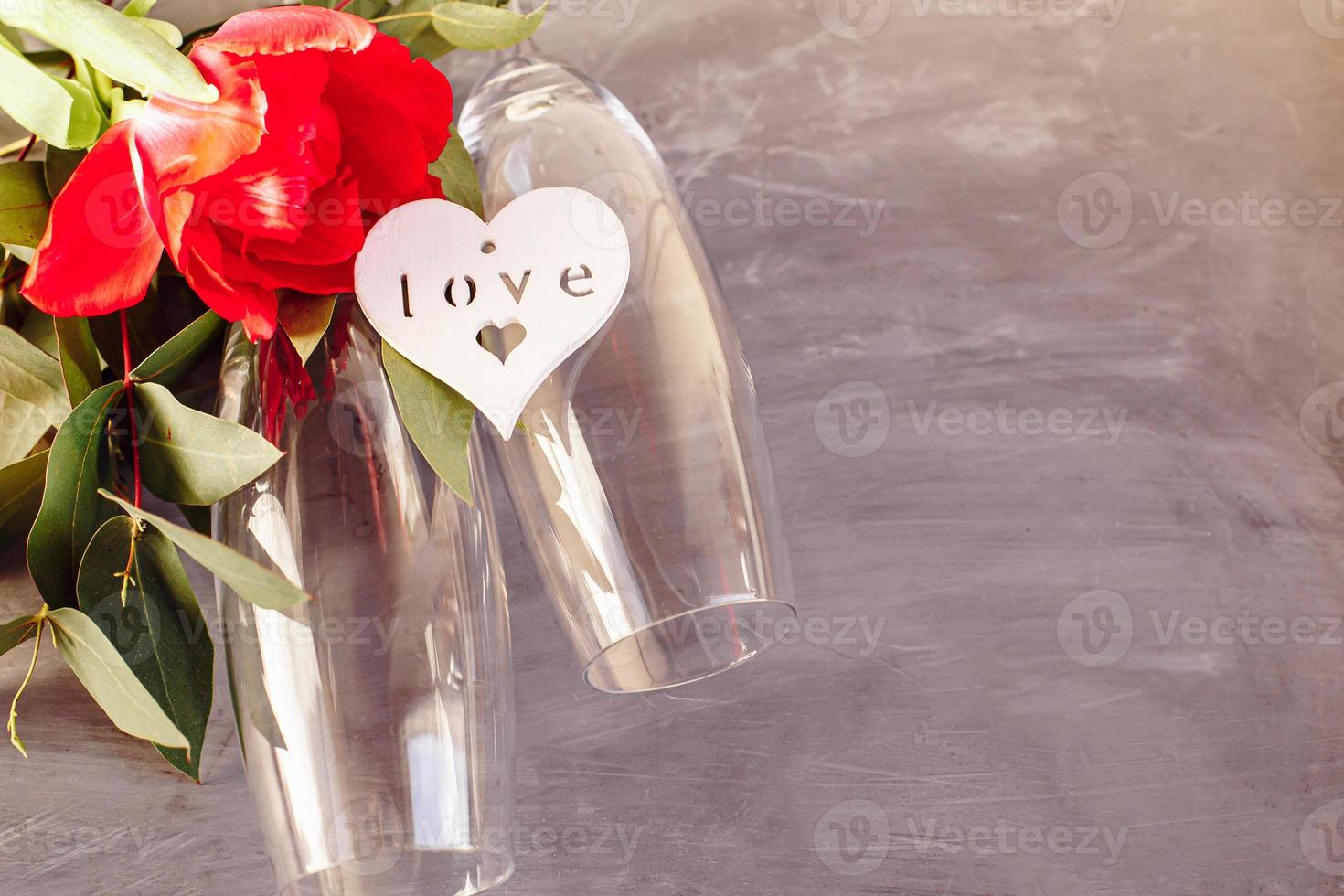 composition avec verre de champagne. fleurs et coeurs sur fond de béton gris. photo