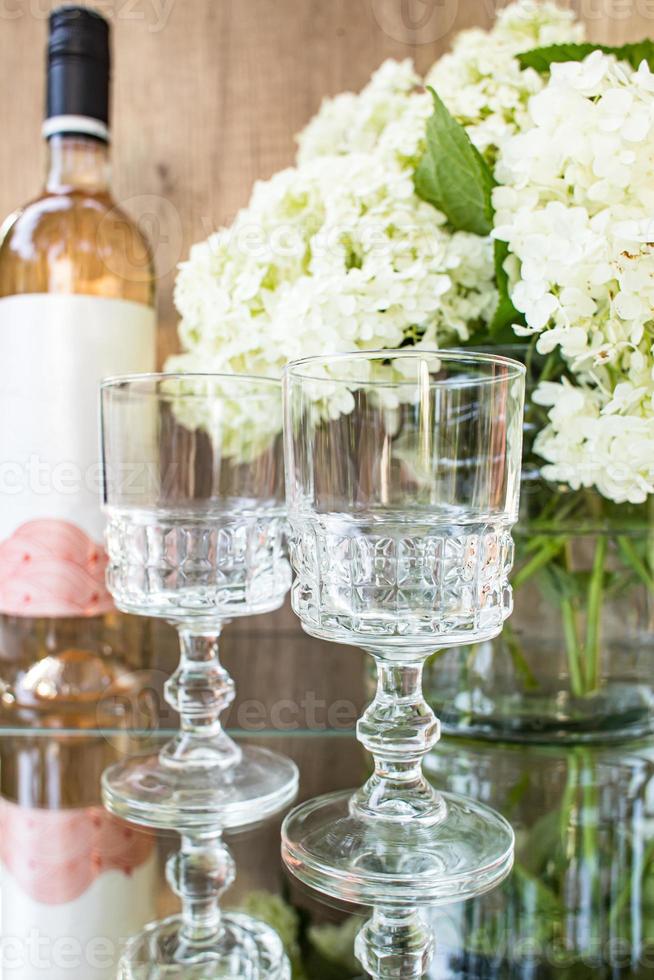 vin rose blush dans des verres. bouteille de vin rosé avec des fleurs sur fond. prosecco. photo