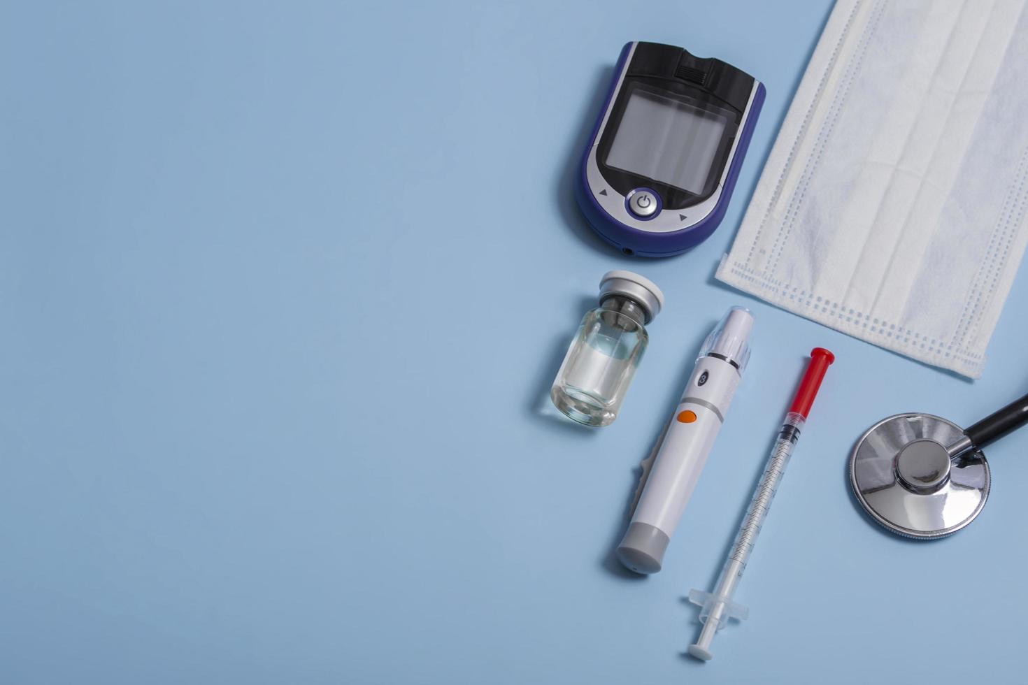 mise en page médicale stéthoscope, glucomètre, seringue, ampoule avec médicament et masque médical sur fond coloré. gros plan photo