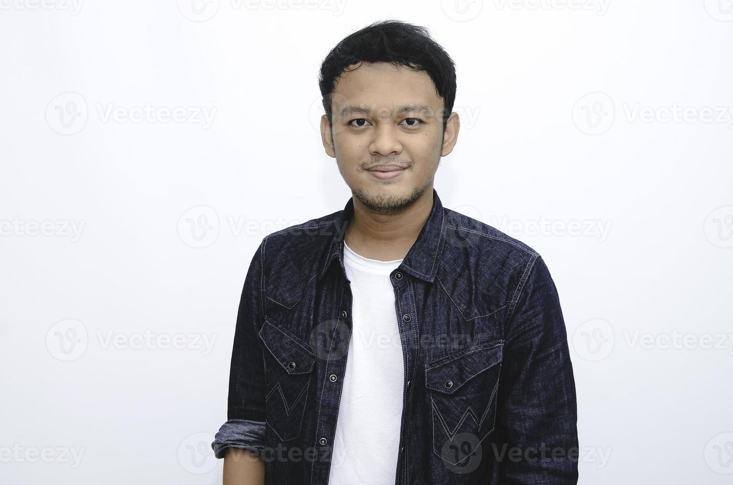 portrait d'un jeune homme asiatique souriant portant une chemise blanche et un pantalon en denim isolé sur blanc. photo