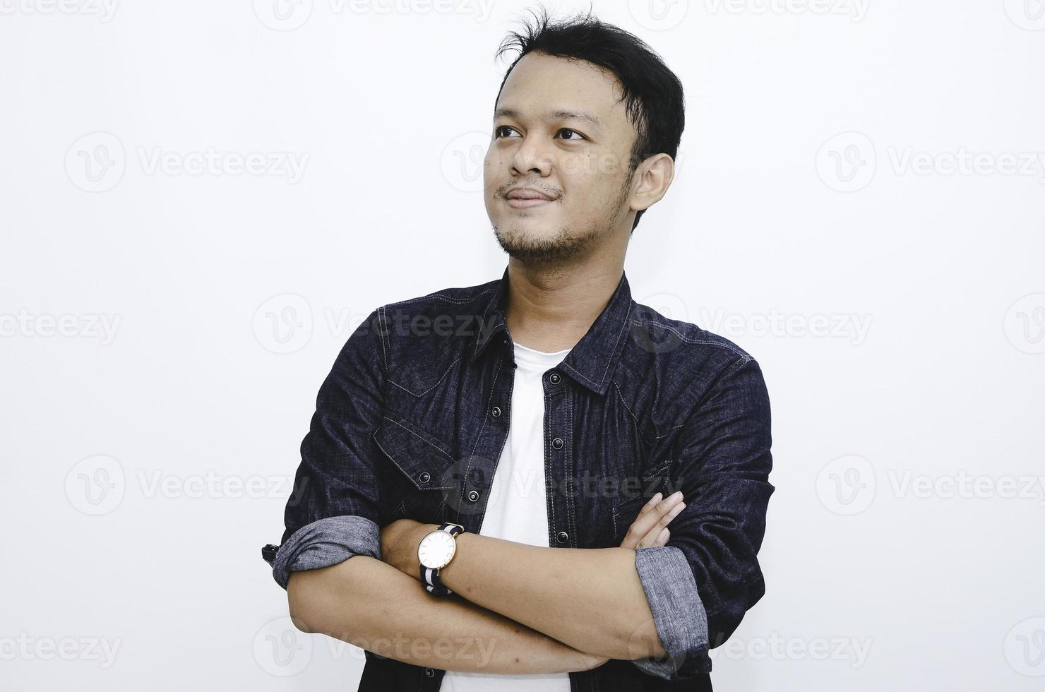 portrait d'un jeune homme asiatique souriant portant une chemise blanche et un pantalon en denim isolé sur blanc. photo