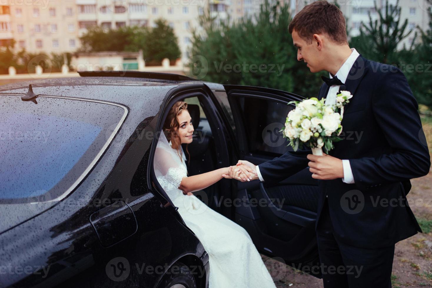 heureuse mariée et le marié près de la voiture. photo