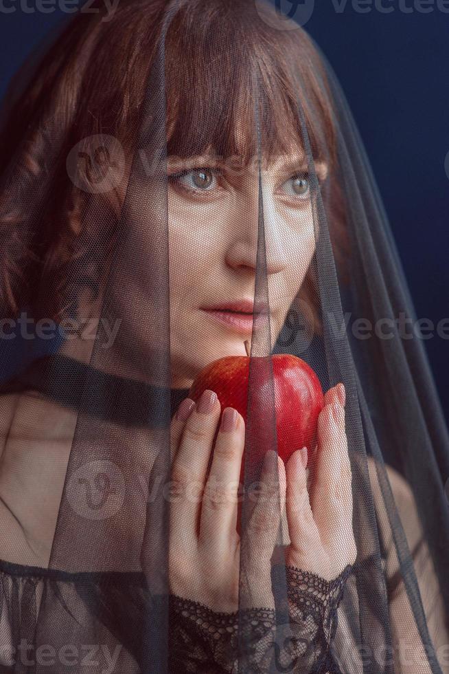 belle femme sorcière avec pomme rouge empoisonnée photo