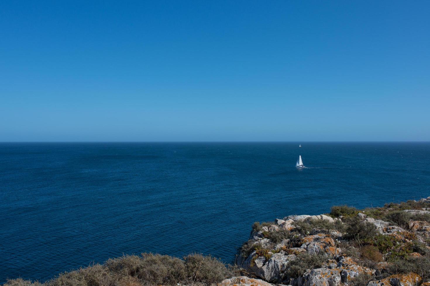 beau paysage marin. journée ensoleillée, eau calme, horizon et un yacht au loin. le Portugal photo