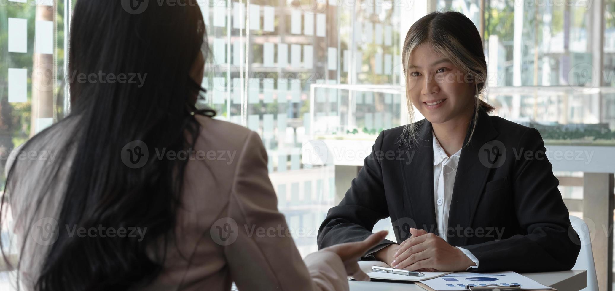 deux jeunes hommes d'affaires asiatiques assis discutant d'un projet d'entreprise et d'une entreprise d'investissement. photo