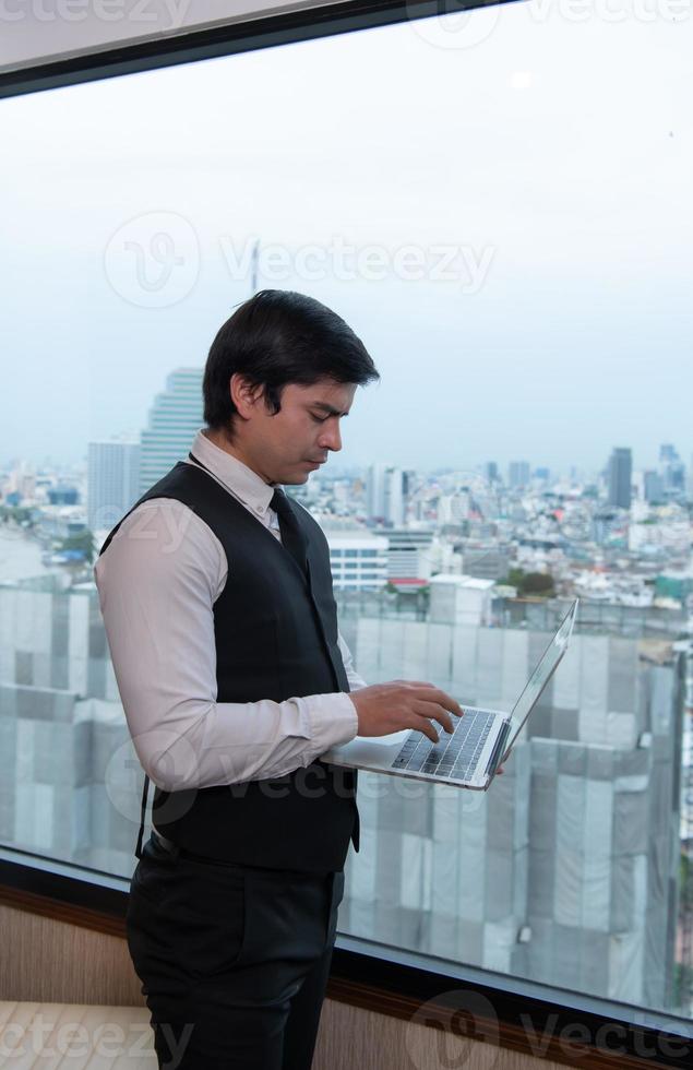 un jeune homme d'affaires surveille et suit les tâches dans son bureau photo