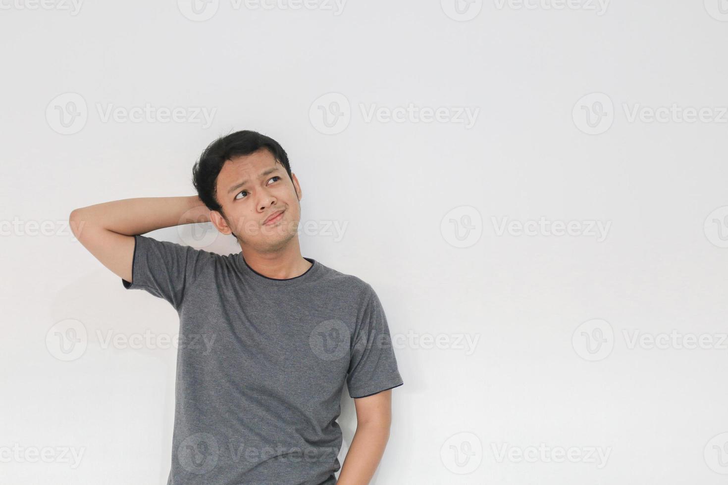 un jeune homme asiatique porte une chemise grise avec un geste d'idée pensant et regardant photo