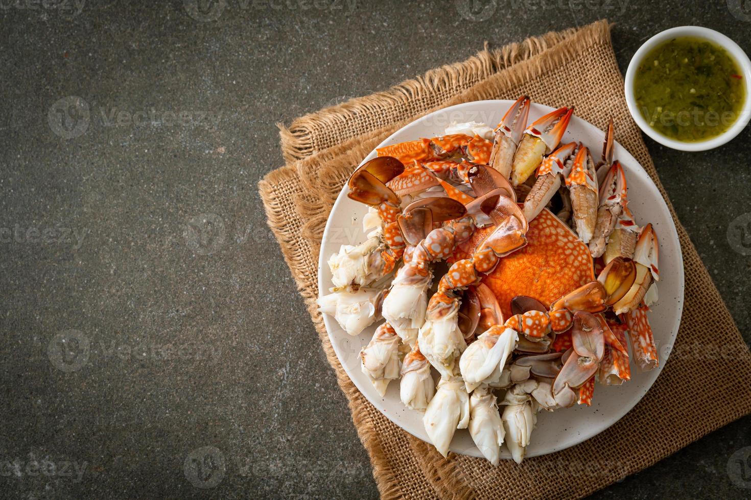 crabe bleu cuit à la vapeur avec sauce épicée aux fruits de mer photo