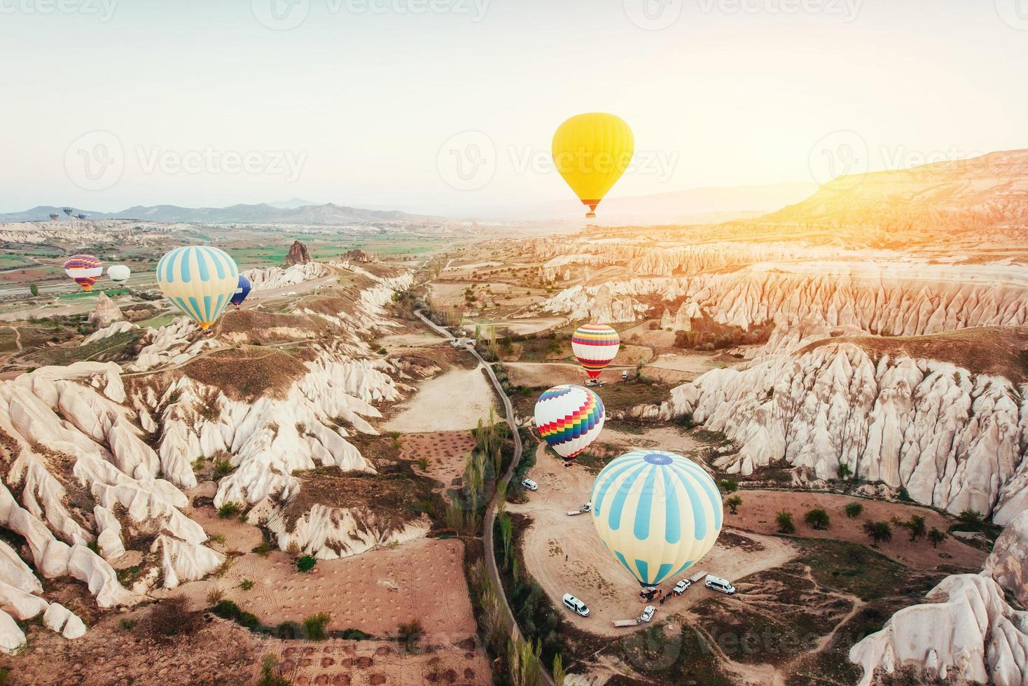 ballon à air chaud survolant le paysage rocheux en turquie. cappadoce photo