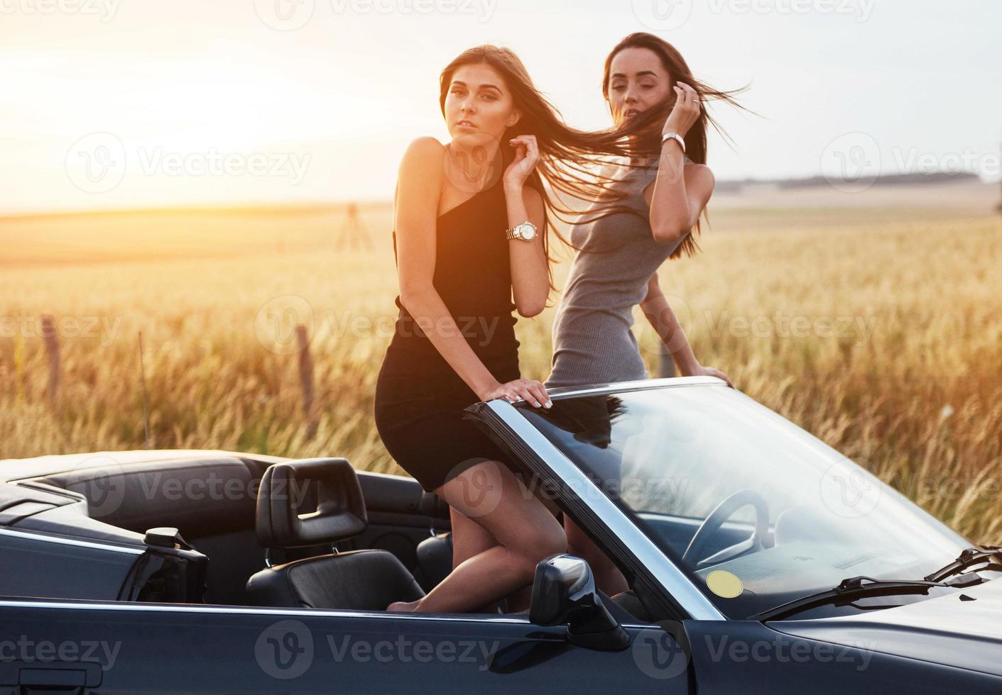 deux femmes dans une voiture noire sur les routes en bordure de route photo