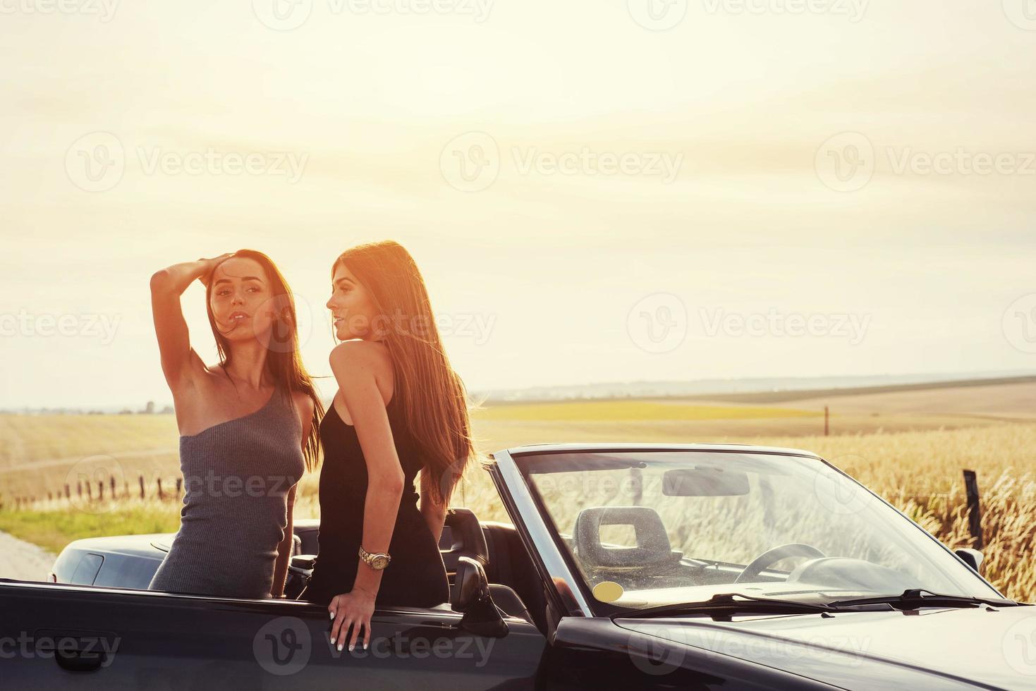 deux femme brune sexy debout près de sa voiture photo