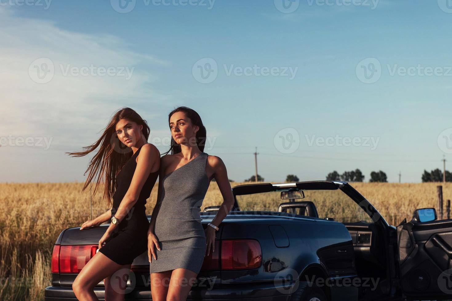 deux femme brune sexy debout près de sa voiture photo