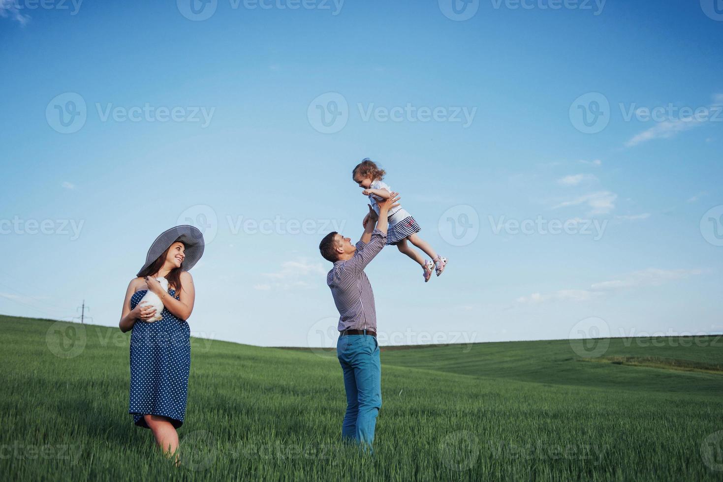 famille heureuse de trois personnes se serrant dans les rues photo