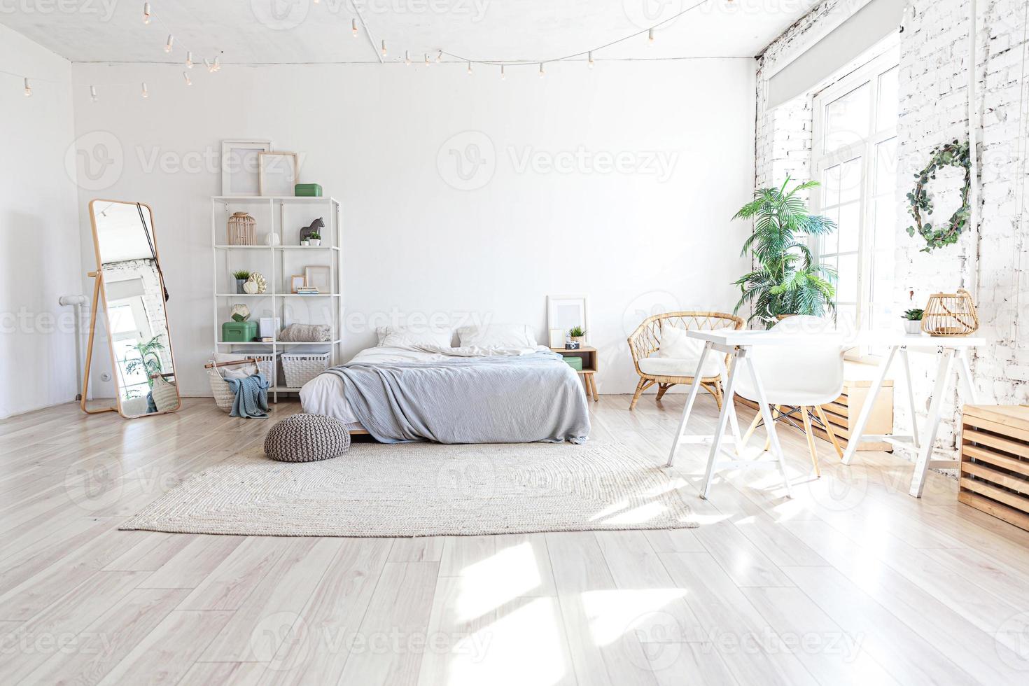 intérieur de chambre loft élégant. appartement design spacieux avec murs clairs grandes fenêtres grand lit. décoration moderne et épurée avec un mobilier élégant de style scandinave minimaliste. photo