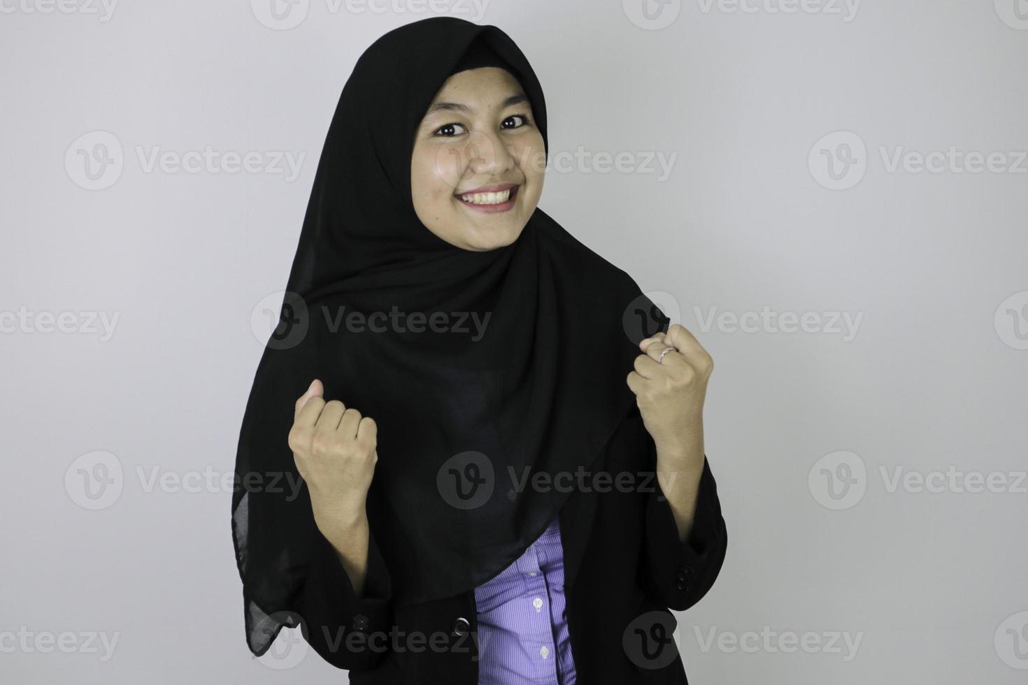 geste excité et gagnant jeune femme islamique asiatique portant le foulard. photo