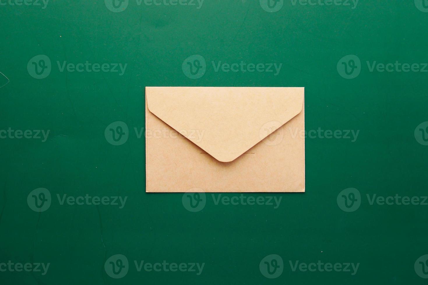 une enveloppe tombe sur un fond de couleur verte photo