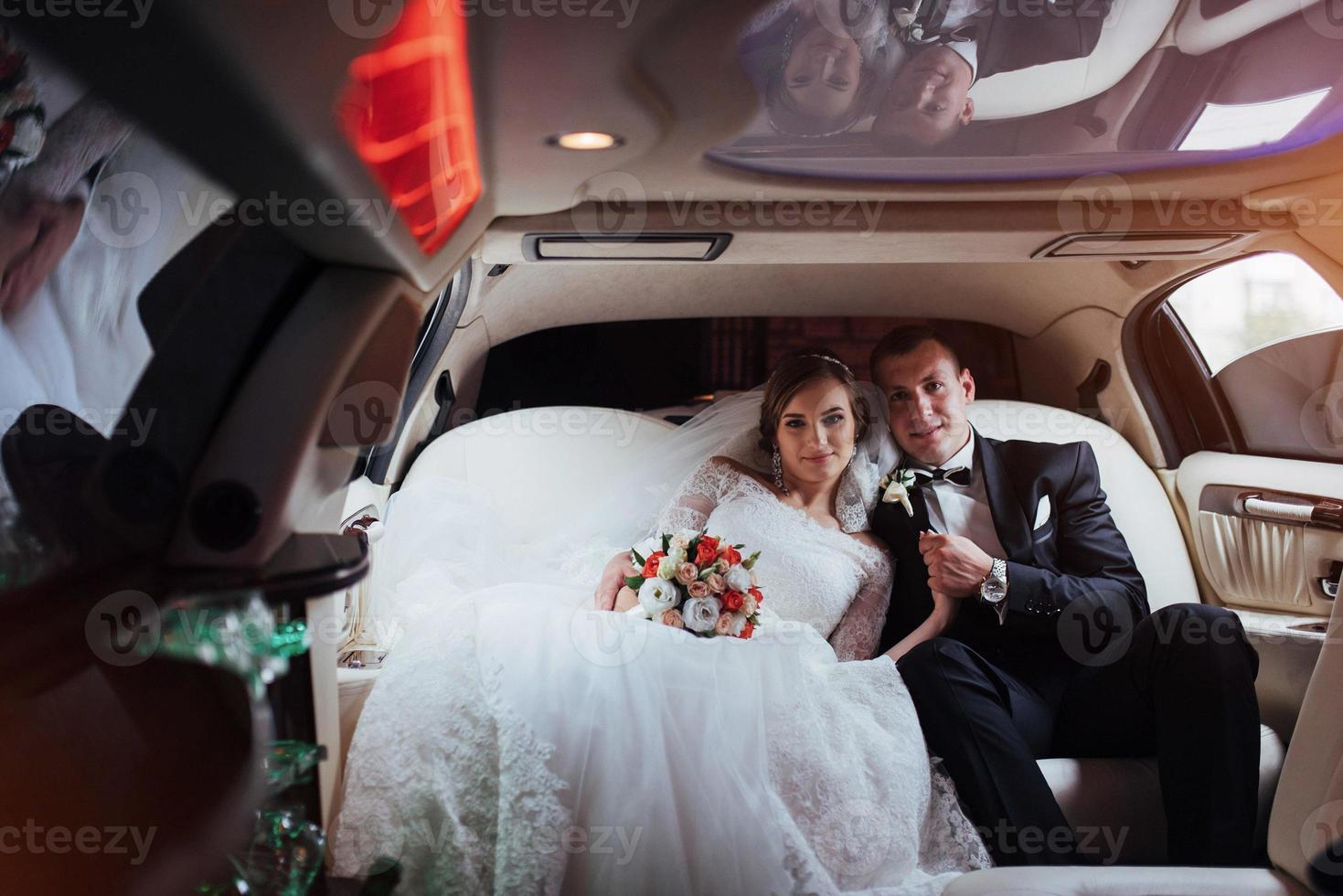 jeune couple dans une voiture le jour du mariage photo