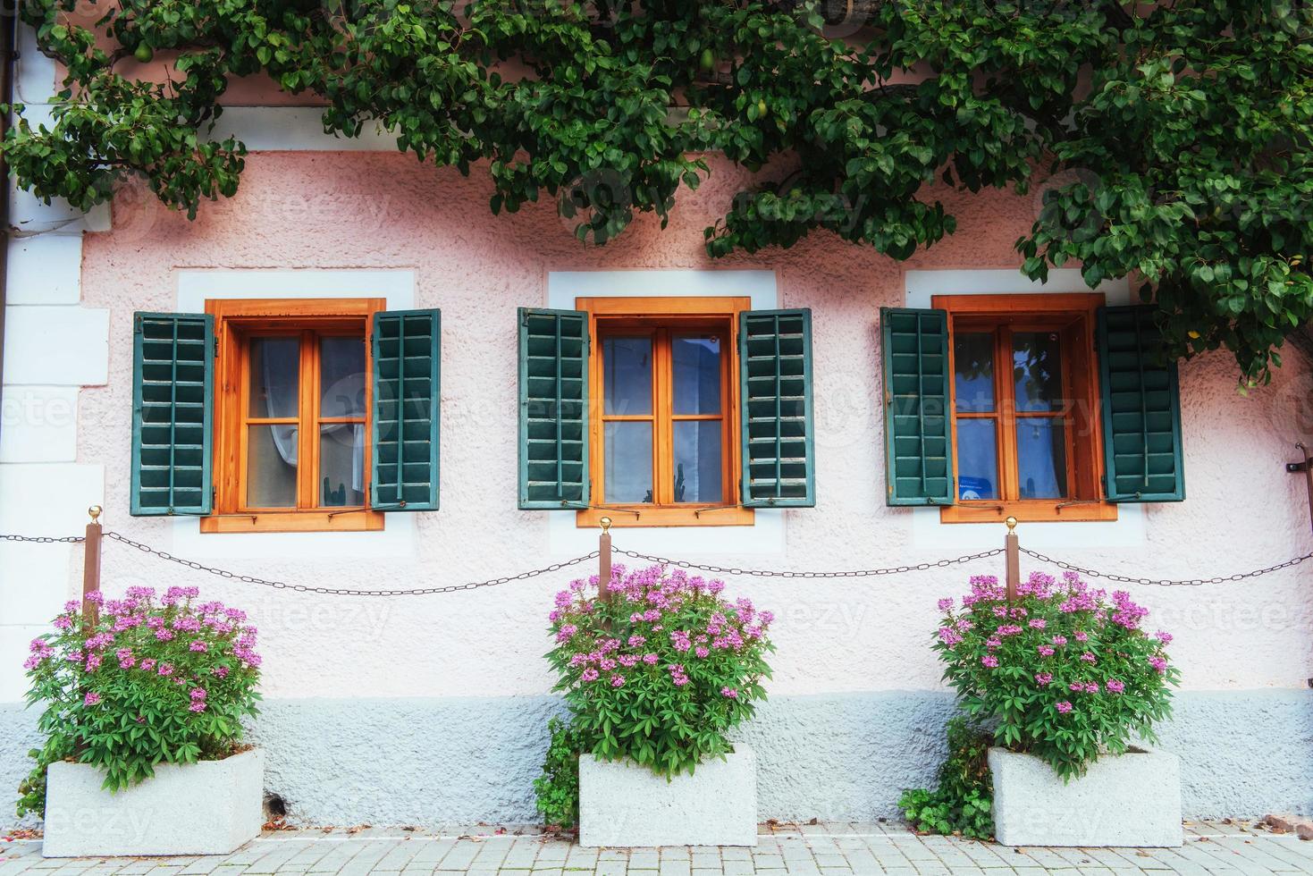 maison alpine autrichienne typique avec des fleurs lumineuses sur le balcon photo