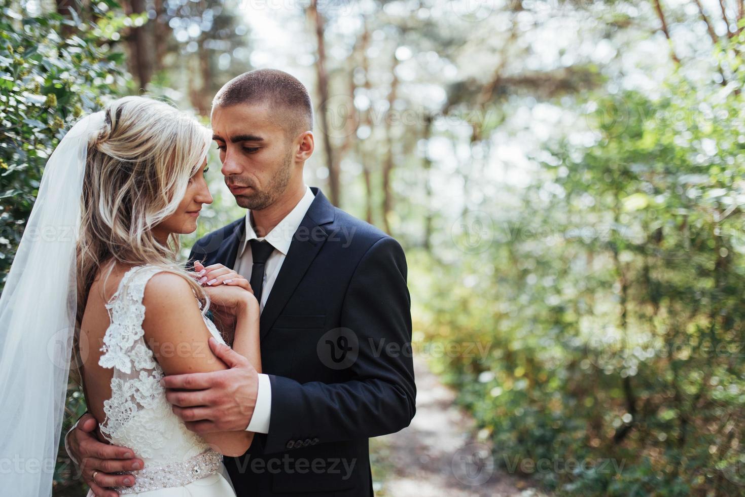 un jeune couple heureux pose pour les photographes lors de son plus beau jour. photo