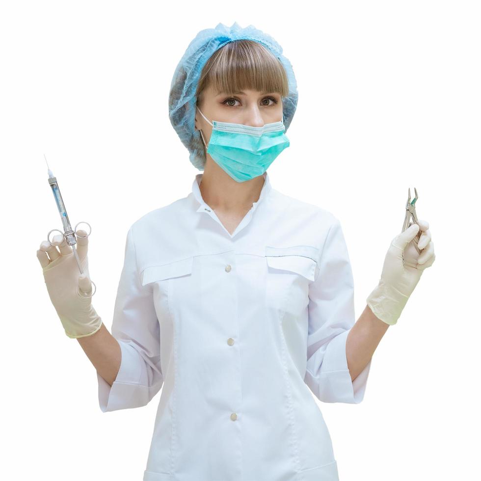 Dentiste femme avec des outils à la main sur fond blanc isolé photo