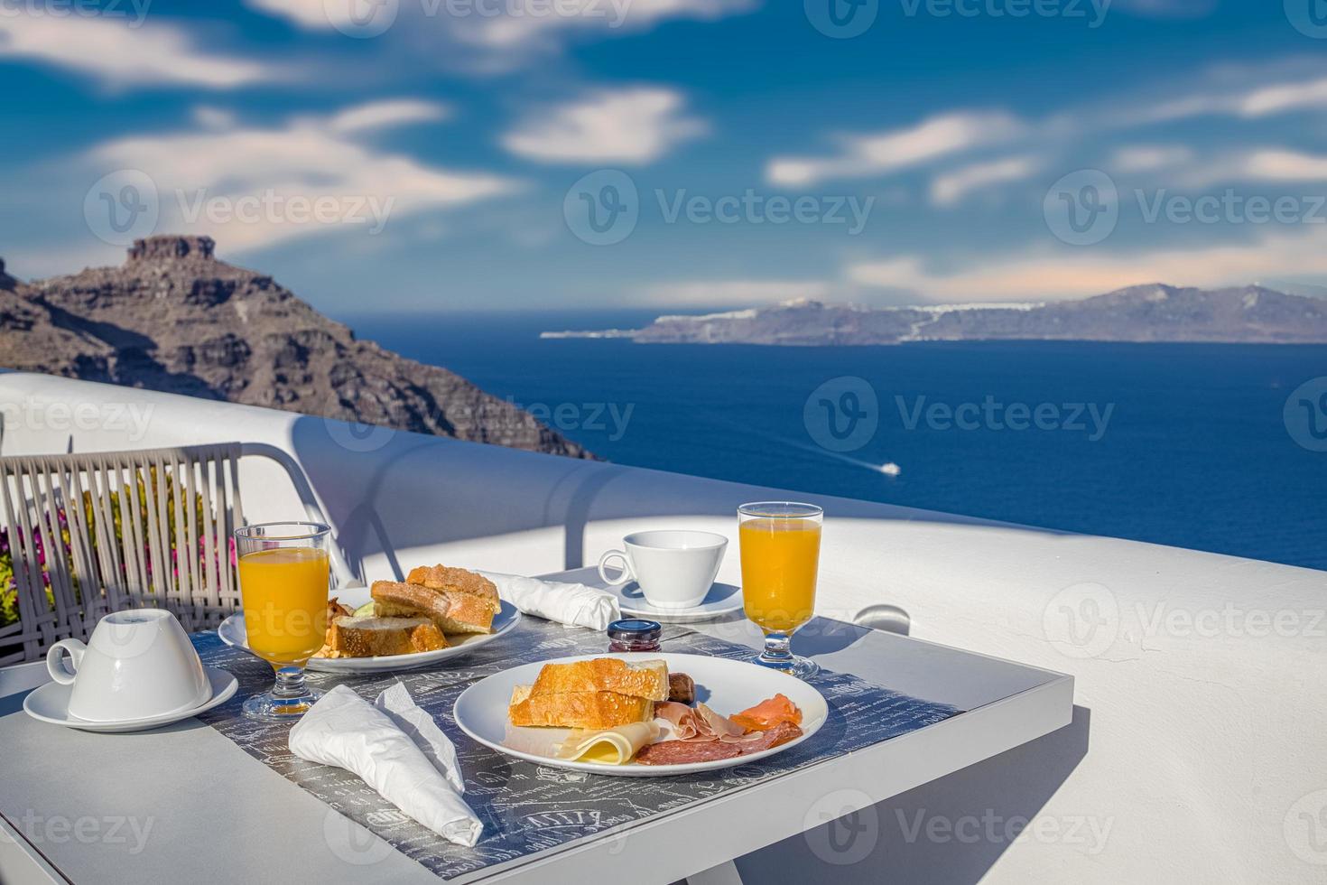 heure du petit déjeuner à santorin à l'hôtel. ambiance de luxe avec omelette fraîche et fruits avec jus sur vue sur la mer. fond de vacances de voyage d'été luxueux. happy relax vibes, table de gros plan du matin en couple photo