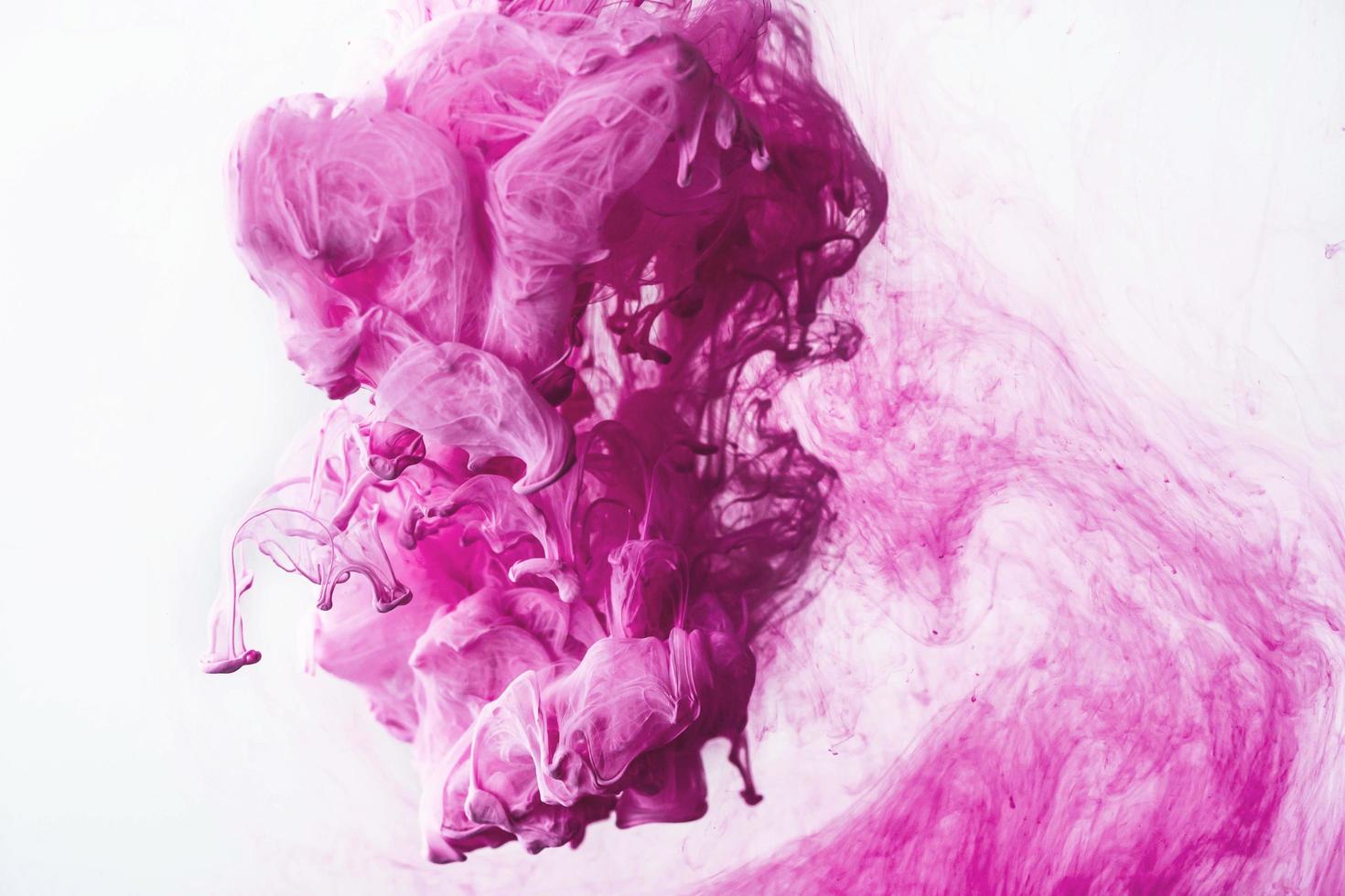 goutte d'encre colorée rose dans l'eau, encre tourbillonnant. image d'abstraction pour l'arrière-plan ou le référent de couleur. photo