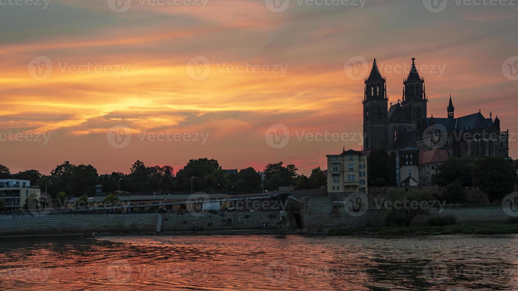 vue panoramique sur la silhouette d'un château médiéval au beau coucher de soleil sanglant au centre-ville historique de magdebourg, vieille ville, fleuve elbe et magnifique cathédrale, allemagne. photo