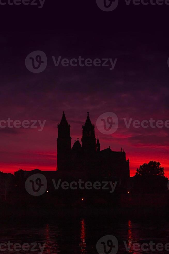 page de garde avec silhouettes d'un château médiéval, cathédrale au beau coucher de soleil sanglant au centre-ville historique de magdebourg, vieille ville, fleuve elbe avec espace de copie pour le texte, allemagne. photo