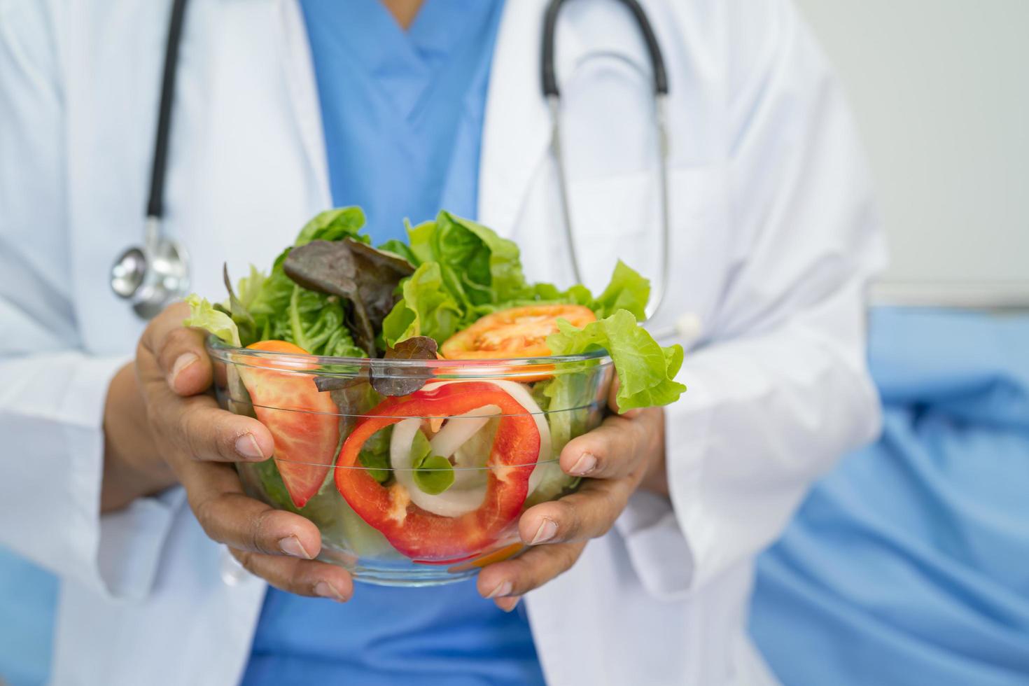 médecin nutritionniste tenant divers légumes frais sains pour le patient. photo