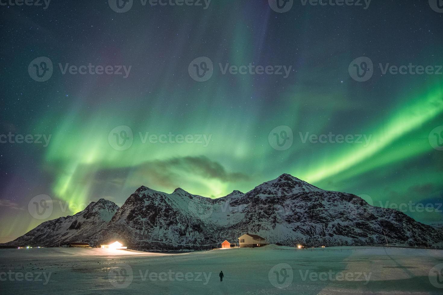 aurores boréales, aurores boréales sur la chaîne de montagnes enneigées de la plage de skagsanden aux îles lofoten photo