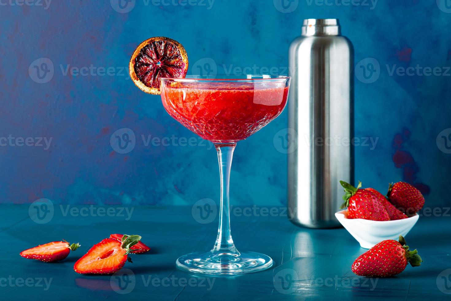 vue détaillée en gros plan d'un cocktail ou d'un jus de fraise avec une tasse élégante et des mûres de fruits. photo