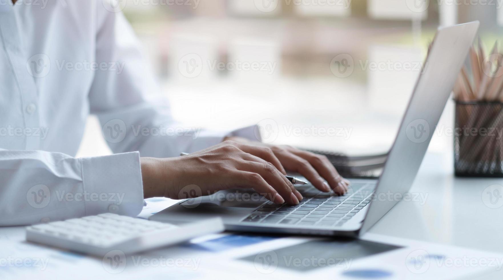 gros plan d'une femme d'affaires à l'aide d'un clavier d'ordinateur portable au bureau. photo