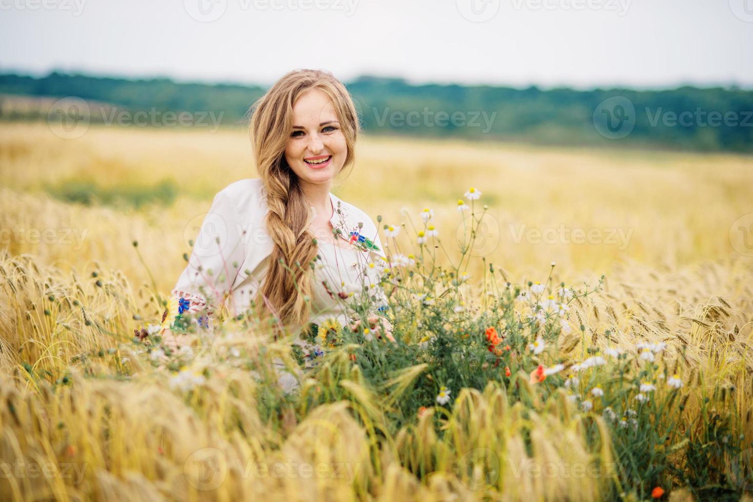 jeune fille à la robe nationale ukrainienne posée au champ de couronne. photo