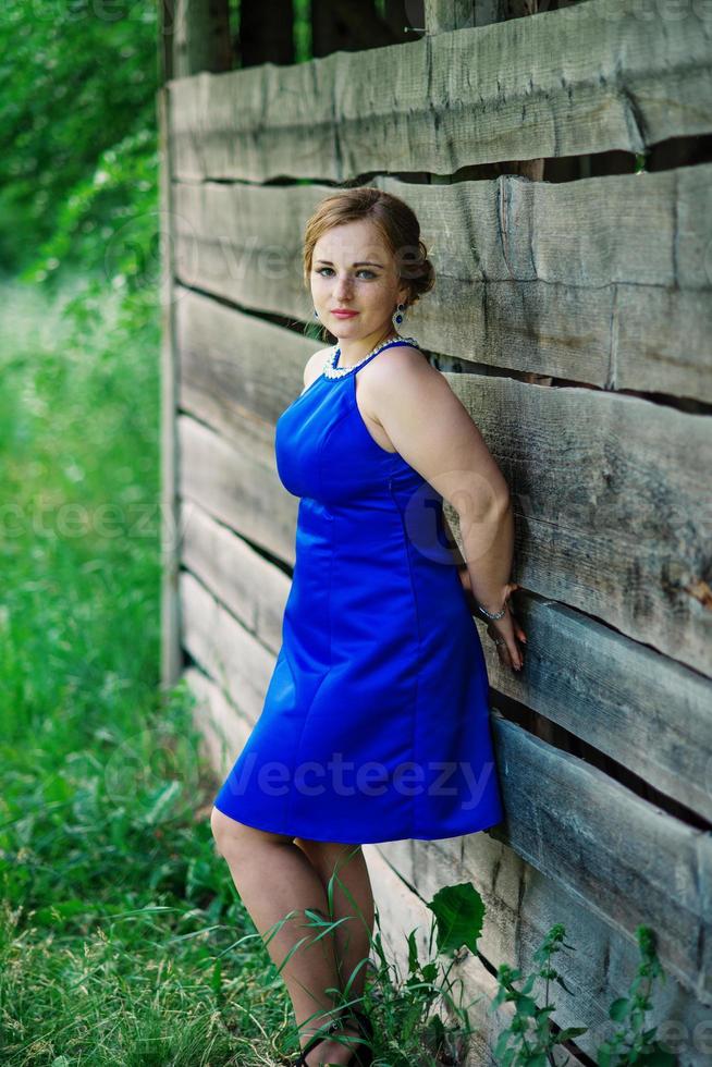 jeune fille en surpoids à la robe bleue posée fond jardin de printemps. photo