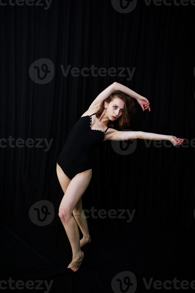 danseuse sautant et dansant sur fond noir. tourné en studio d'une femme qui danse. photo