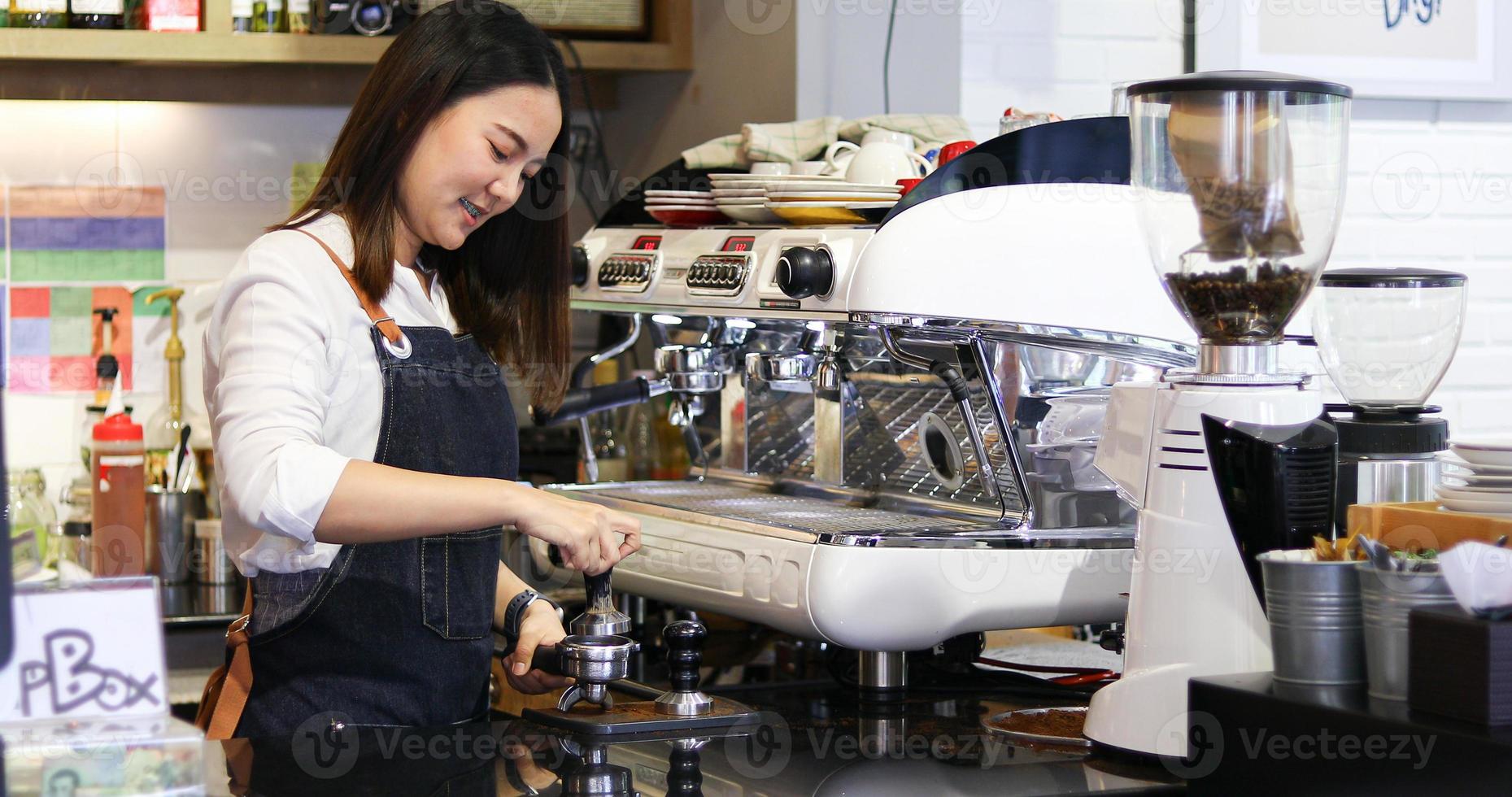 femmes asiatiques barista souriant et utilisant une machine à café dans un comptoir de café - femme qui travaille propriétaire de petite entreprise concept de café de nourriture et de boisson photo