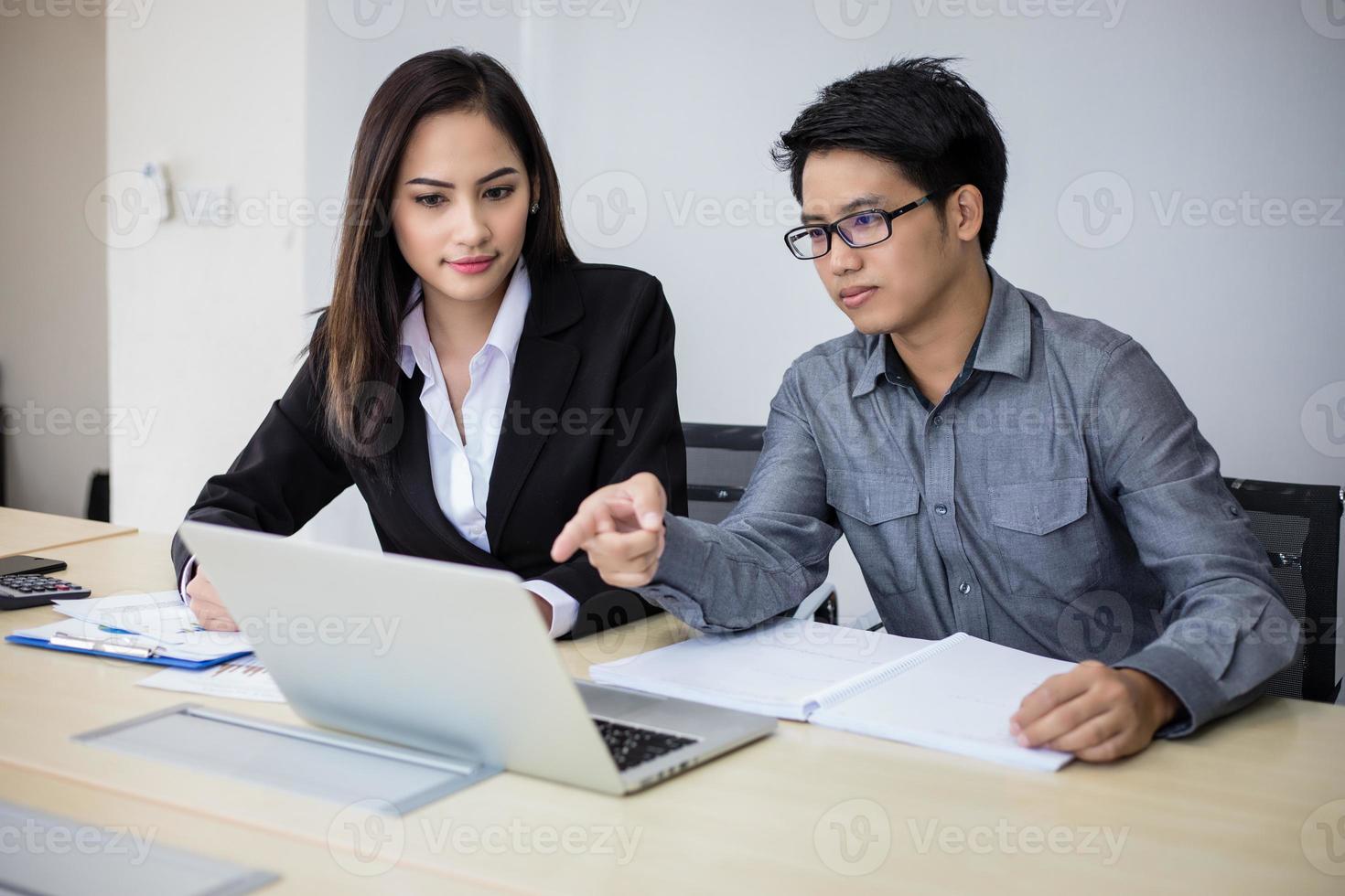hommes d'affaires et groupe asiatiques utilisant un ordinateur portable pour des partenaires commerciaux discutant de documents et d'idées lors d'une réunion et des femmes d'affaires souriantes heureuses de travailler photo